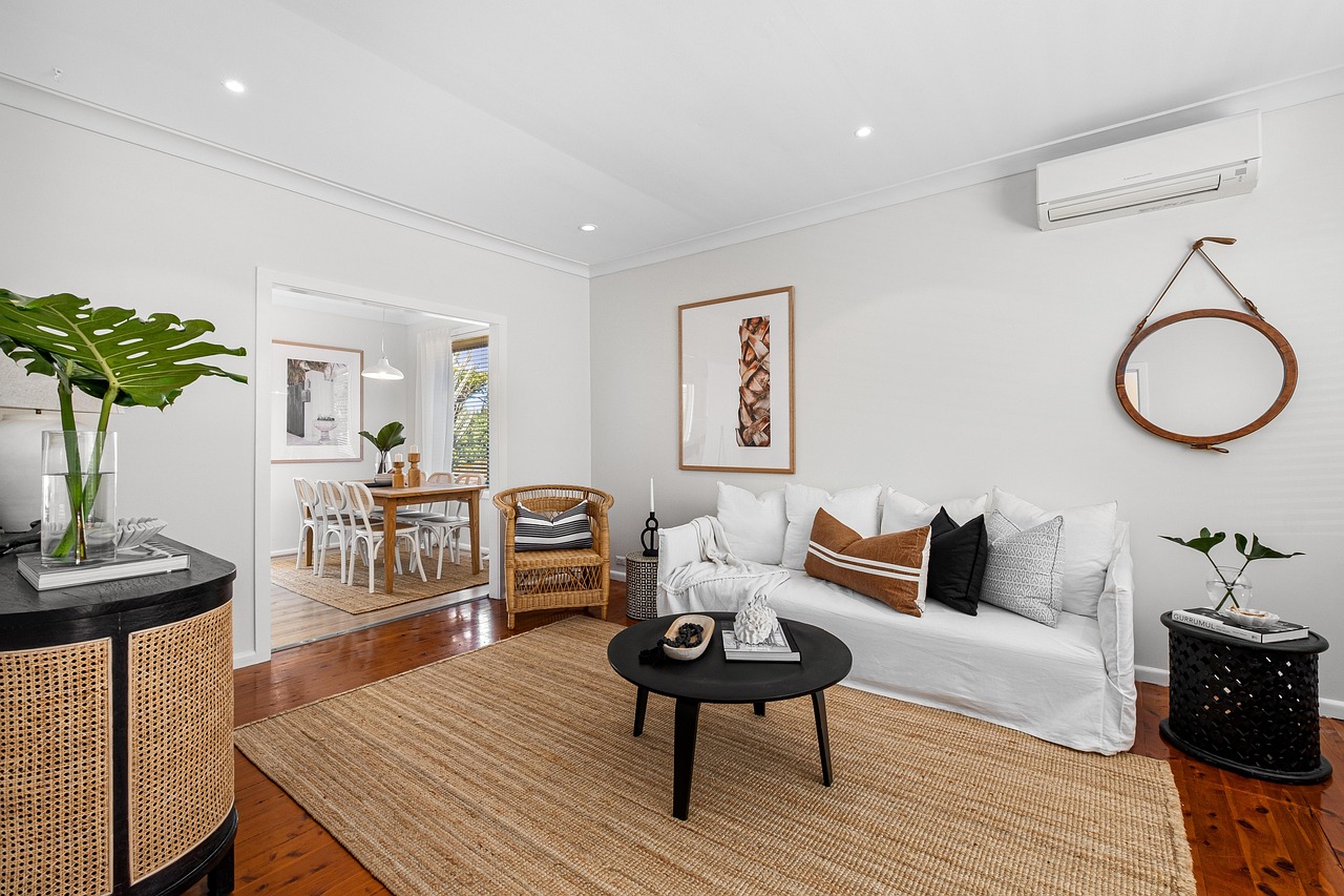 A bright living room with a white sofa, a jute rug and warm timber floors