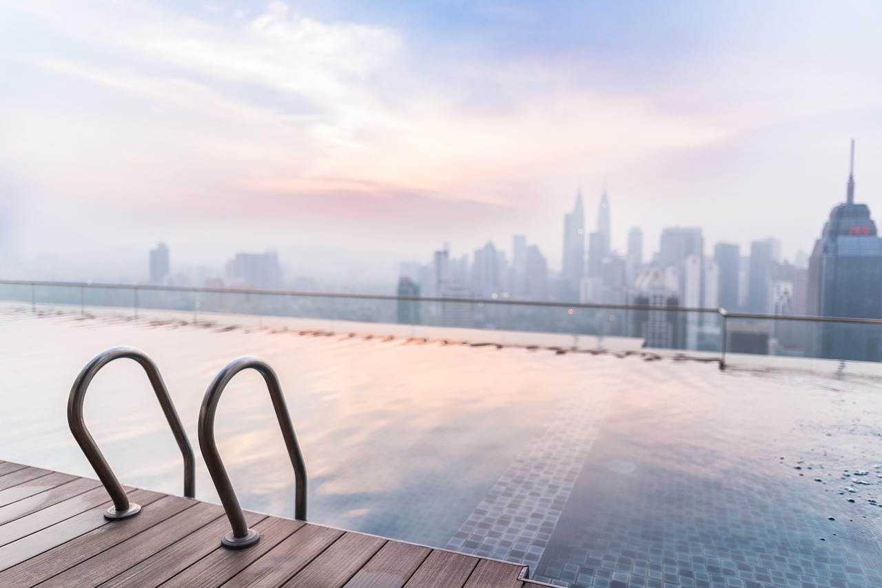 An infinity pool at sunset looking over a city skyline